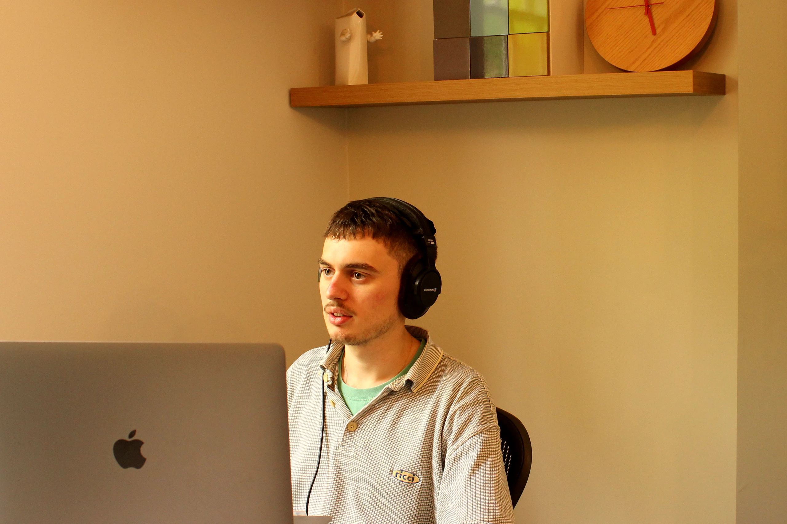 Digital Engagement Manager Dom wearing headphones looking at monitor