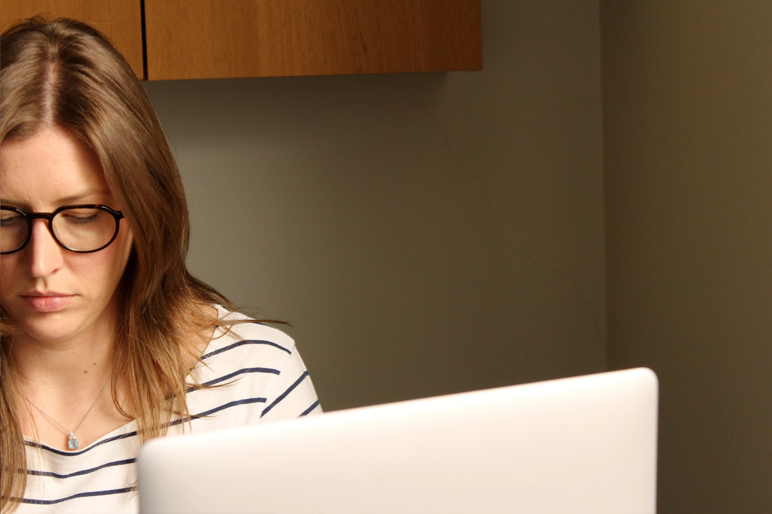 Project manager Katy sat at desk looking down and typing