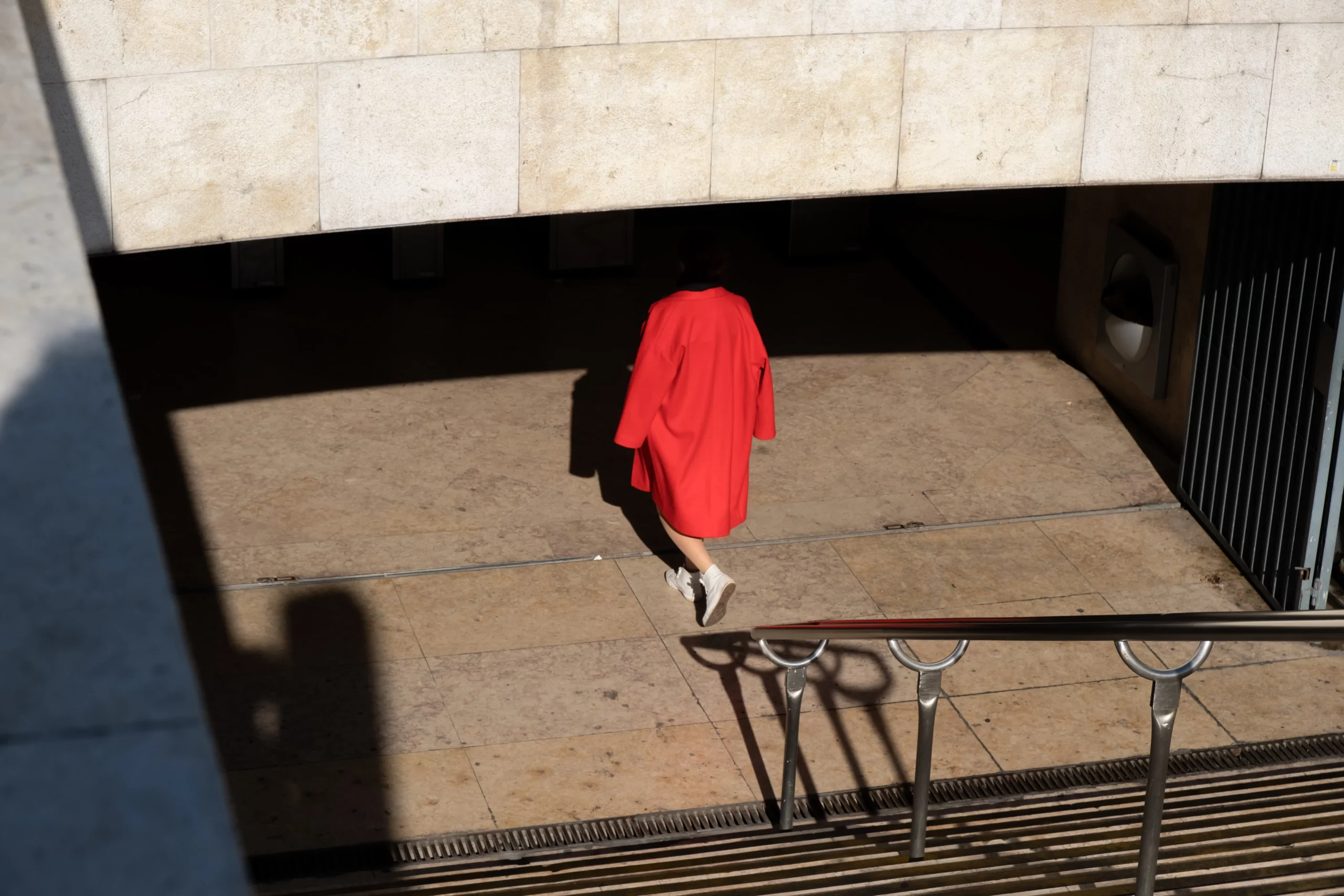 person walking under bridge with their head hidden